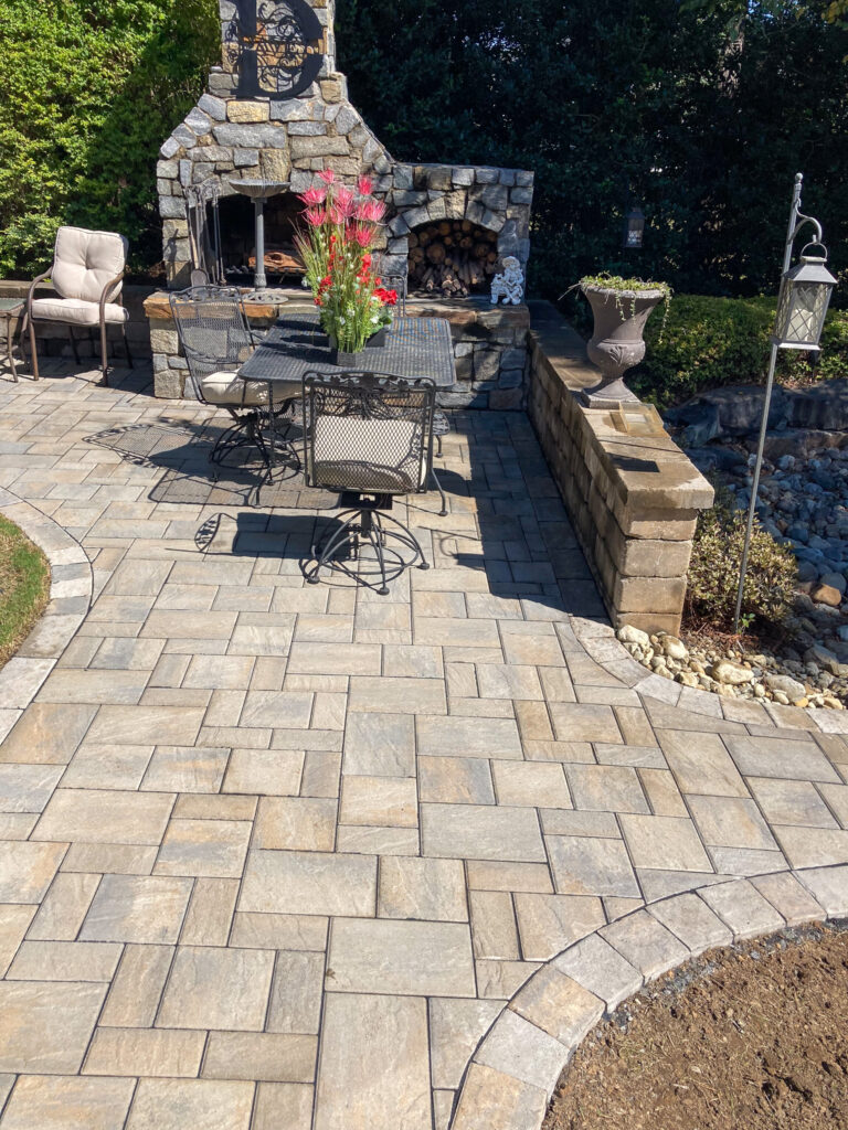 Stone outdoor fireplace on a paver patio in Holly Springs, NC, built by Birch & Boulder