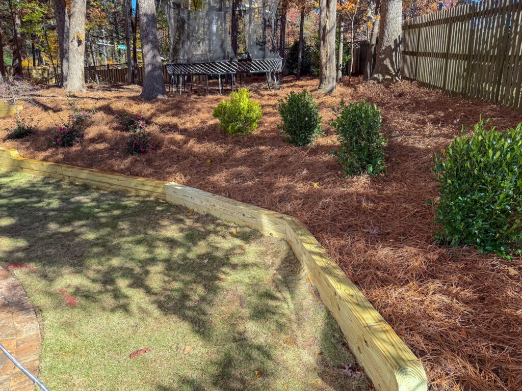 Wood retaining wall with drainage and beautification in Holly Springs NC